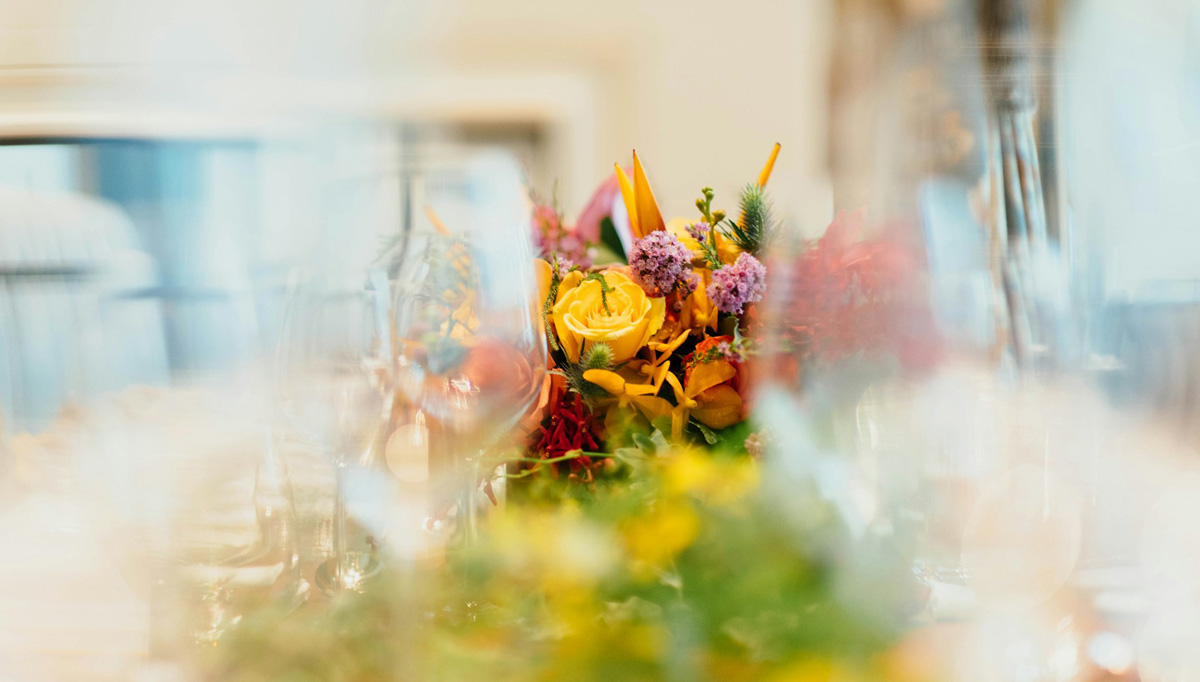 Ein Blumenstrauß stehe auf einem feierlich gedeckten Tisch